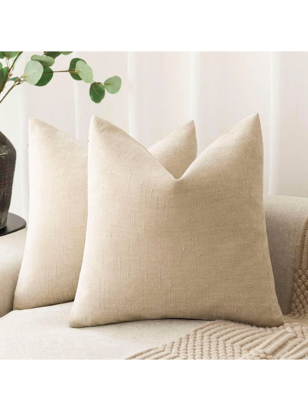 Natural beige textured linen look throw pillow cover on cream sofa