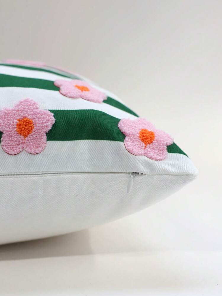 Decorative pillow with green stripes and pink flowers on a white background