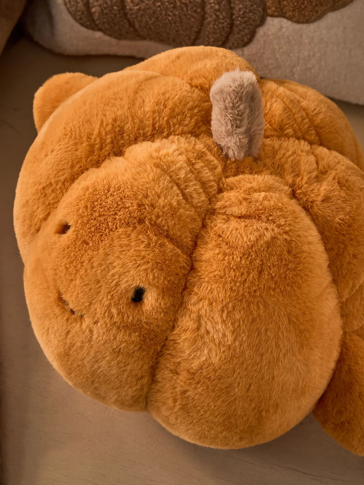 Close up top view of 3D faux fur pumpkin cushion showing cream stem detail and deep ribbed texture