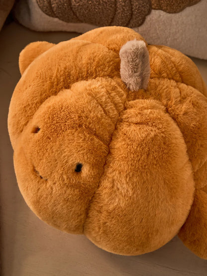 Close up top view of 3D faux fur pumpkin cushion showing cream stem detail and deep ribbed texture