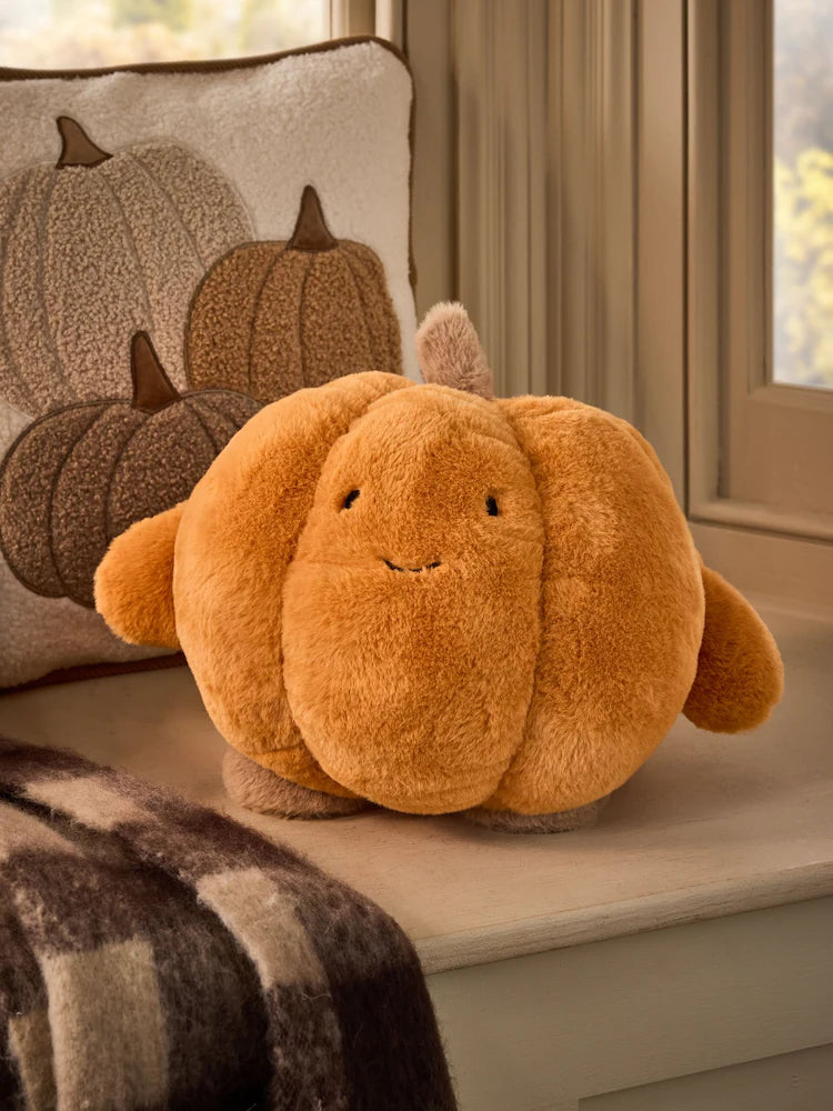 3D faux fur pumpkin cushion in warm orange with embroidered smiley face on cream window seat styled with pumpkin pillow covers