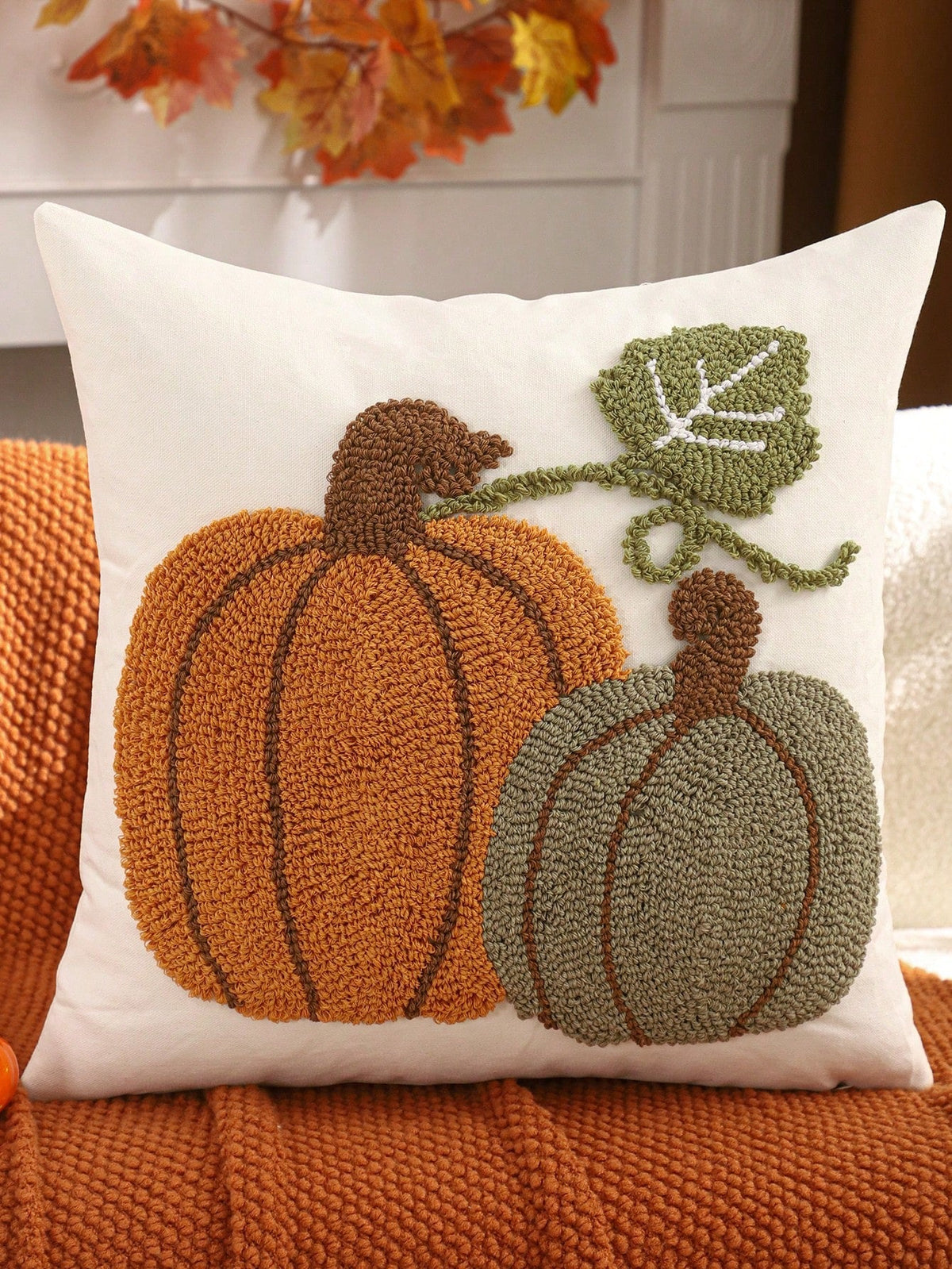 Tufted pumpkin duo cushion cover - orange & sage on white, styled on burnt orange knit sofa with autumn leaf decor