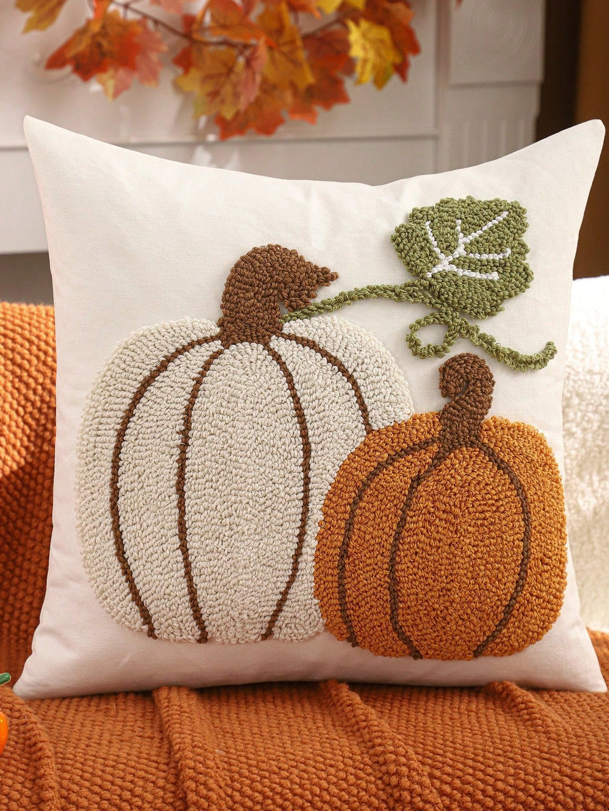 Tufted pumpkin duo cushion cover - cream & orange on white, styled on burnt orange knit sofa with autumn leaf decor