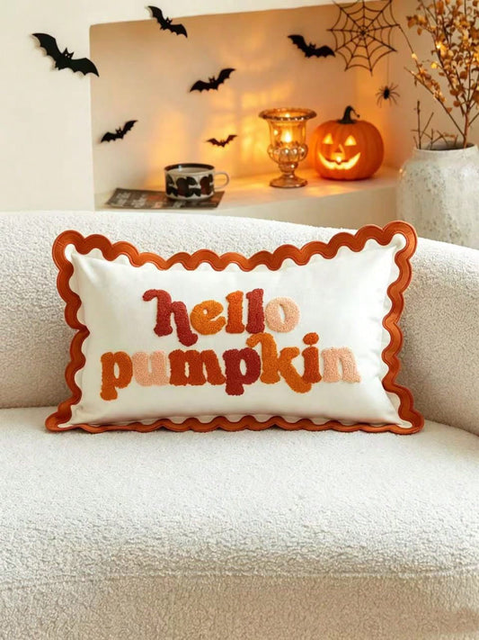 Hello Pumpkin tufted lumbar cushion cover with scalloped wavy orange border on white boucle sofa styled with glowing Halloween jack-o-lantern and bats wall decor