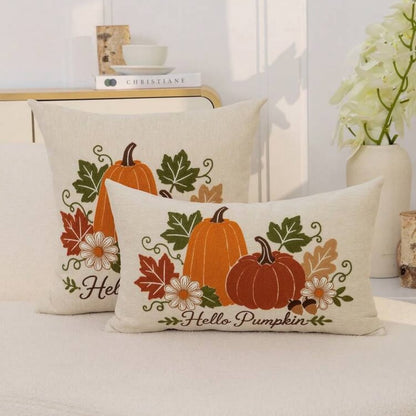 Hello Pumpkin embroidered cushion covers in sage green and cream lumbar sizes side by side on white surface with dresser background
