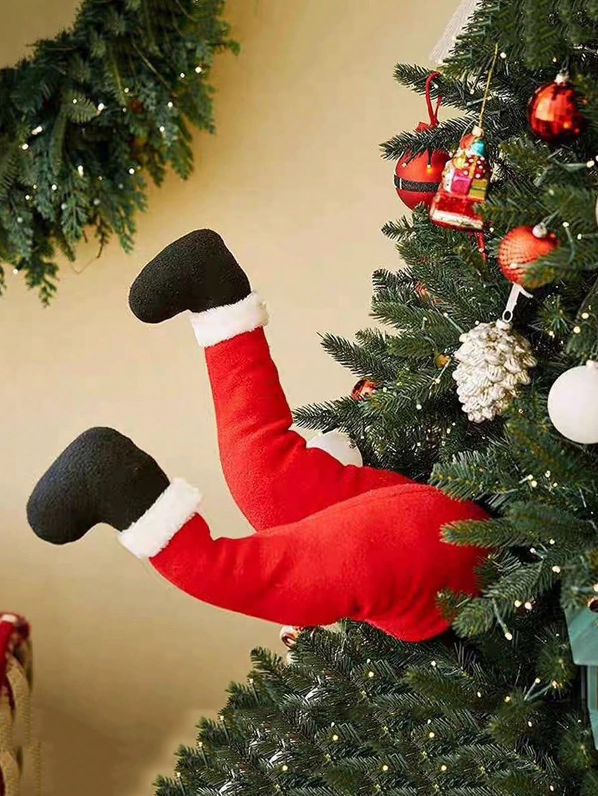 Santa legs sticking out of Christmas tree - funny holiday decoration
