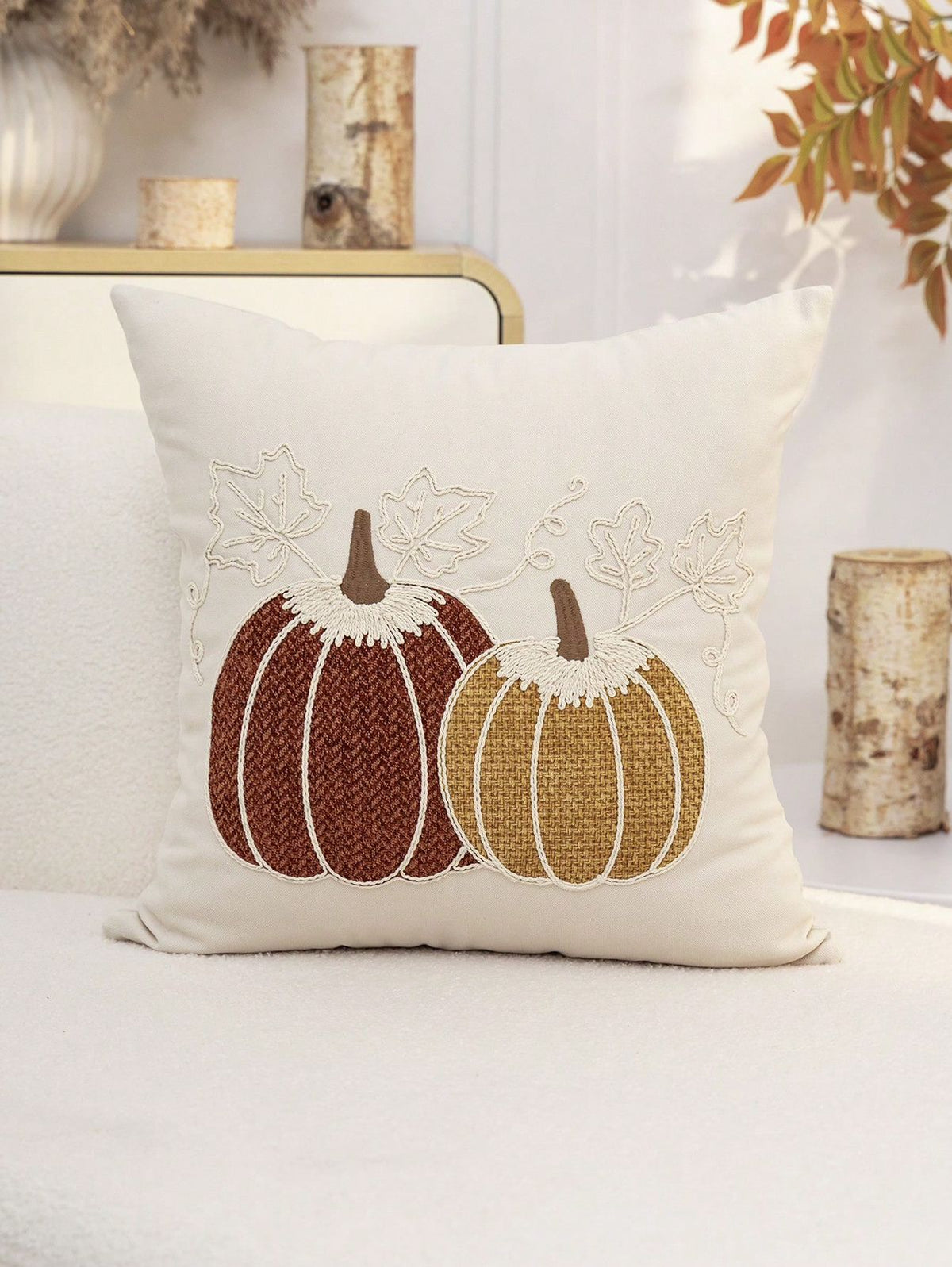 Embroidered pumpkin pillow cover in cream background on sofa with autumn decor