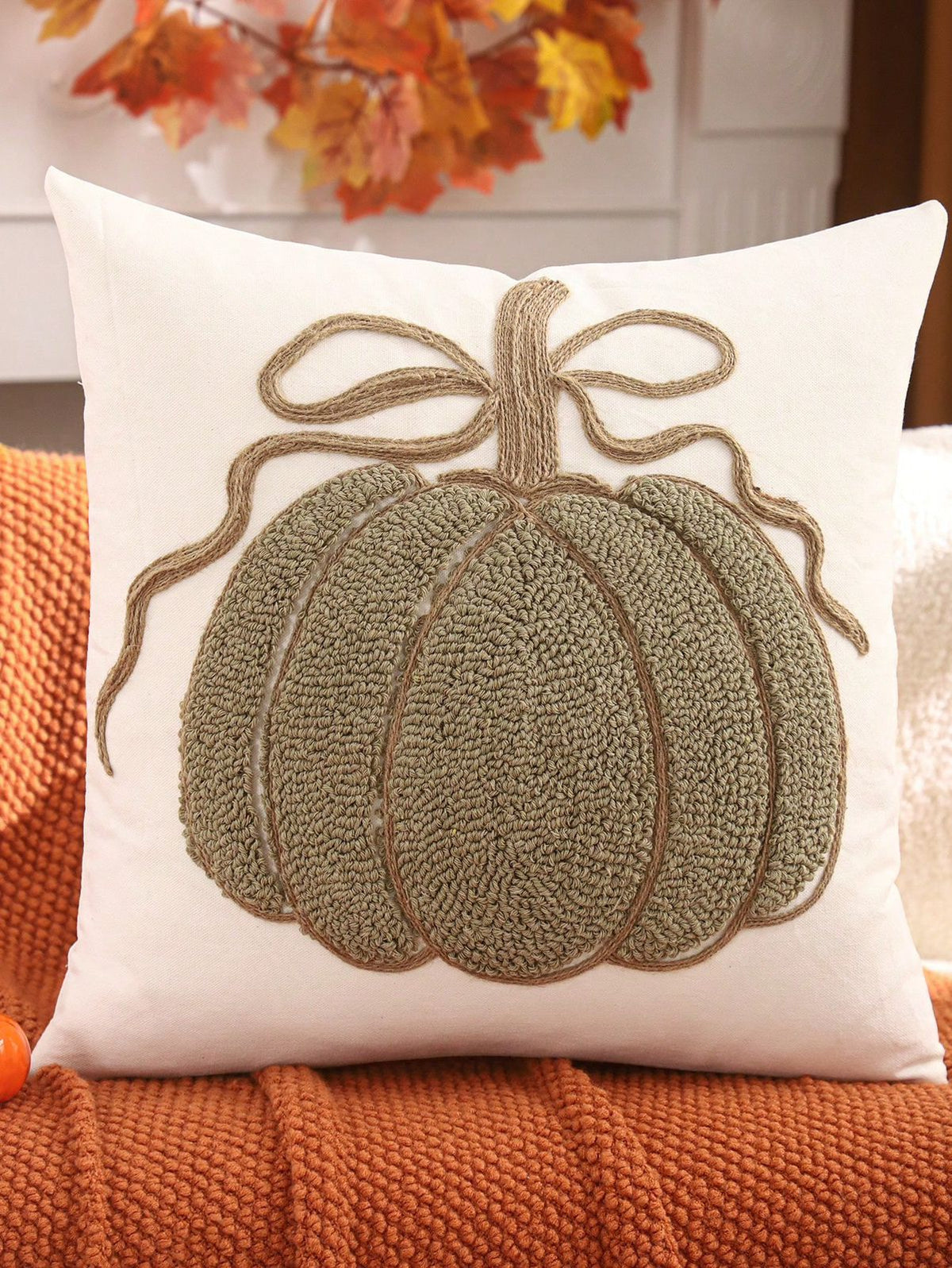 Chenille pumpkin pillow cover in sage green with jute bow on rust orange throw