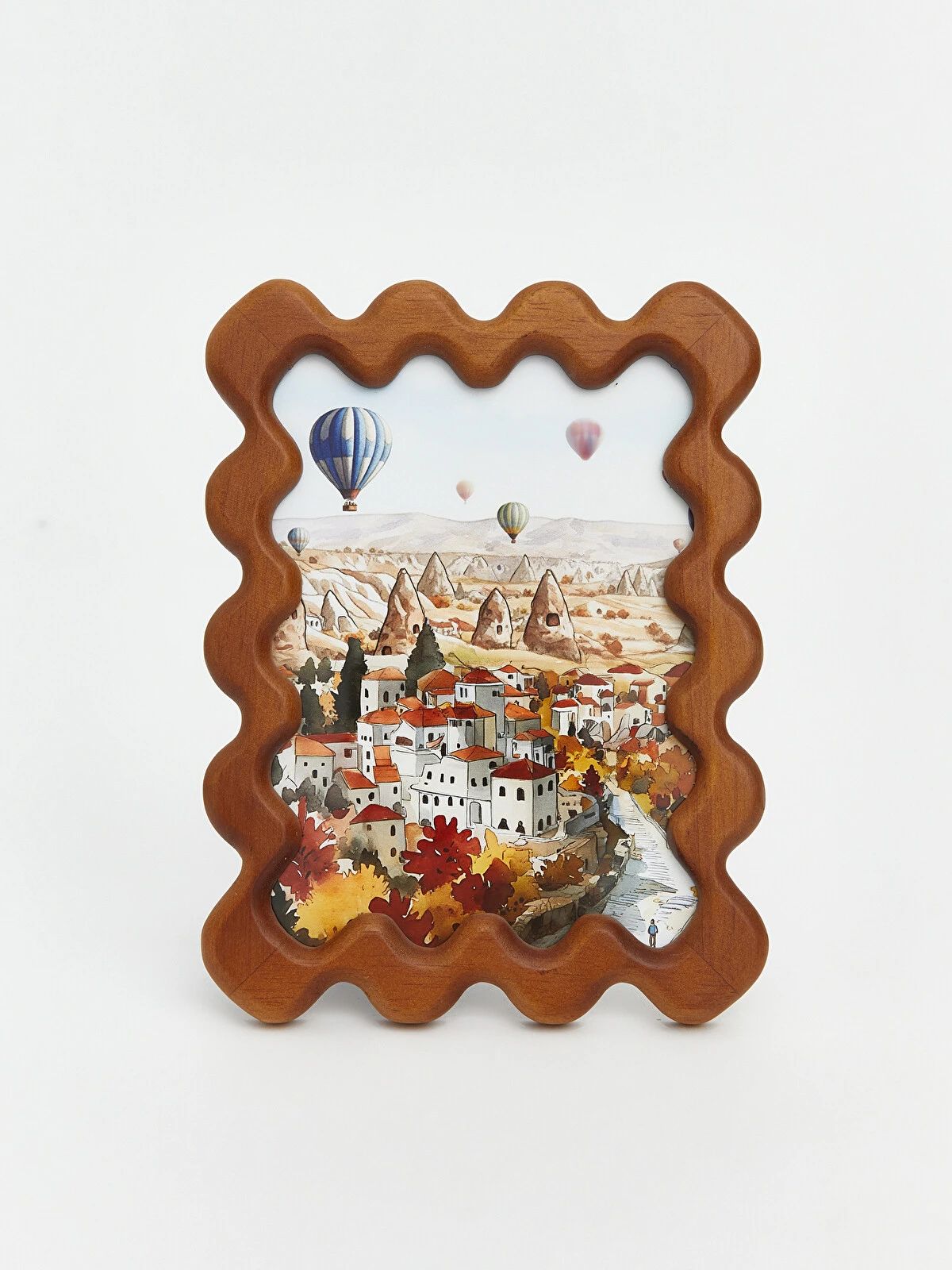 Wavy edge brown decorative photo frame on cream shelf styled with Cappadocia hot air balloon landscape print and books