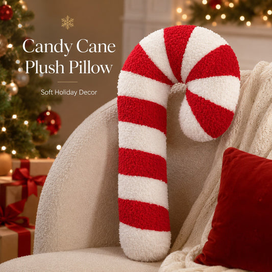 Candy cane plush pillow in red and white boucle stripes leaning on cream armchair with glowing Christmas tree and fairy lights