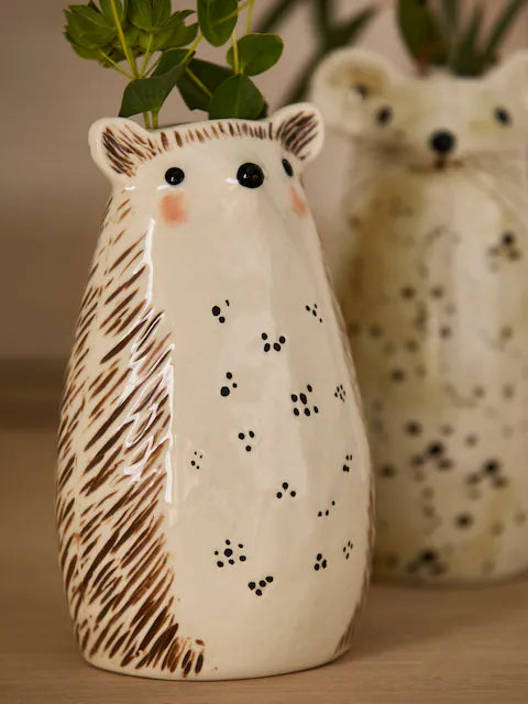 Close up of hedgehog ceramic bud vase with green herb stems showing rosy cheeks, bead eyes and spine texture detail