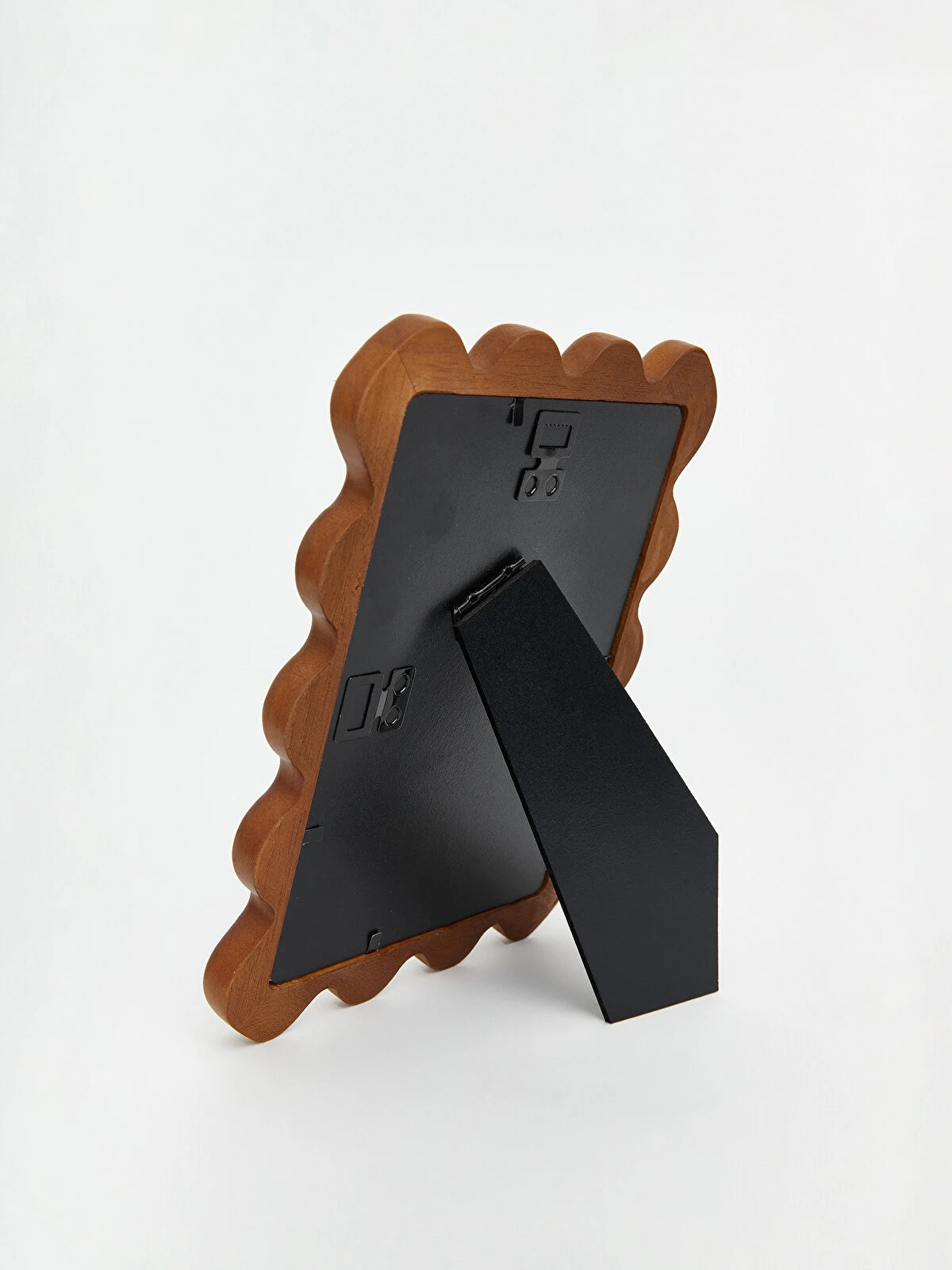 Back view of wavy edge photo frame showing freestanding black easel back stand on white background