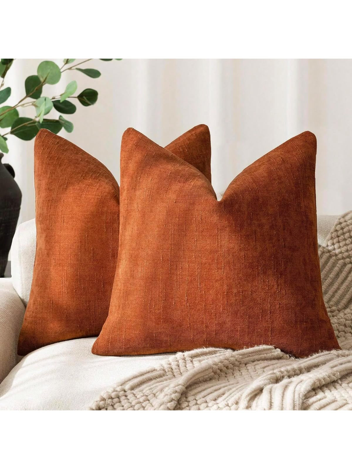 Rust orange textured linen look throw pillow cover on cream sofa