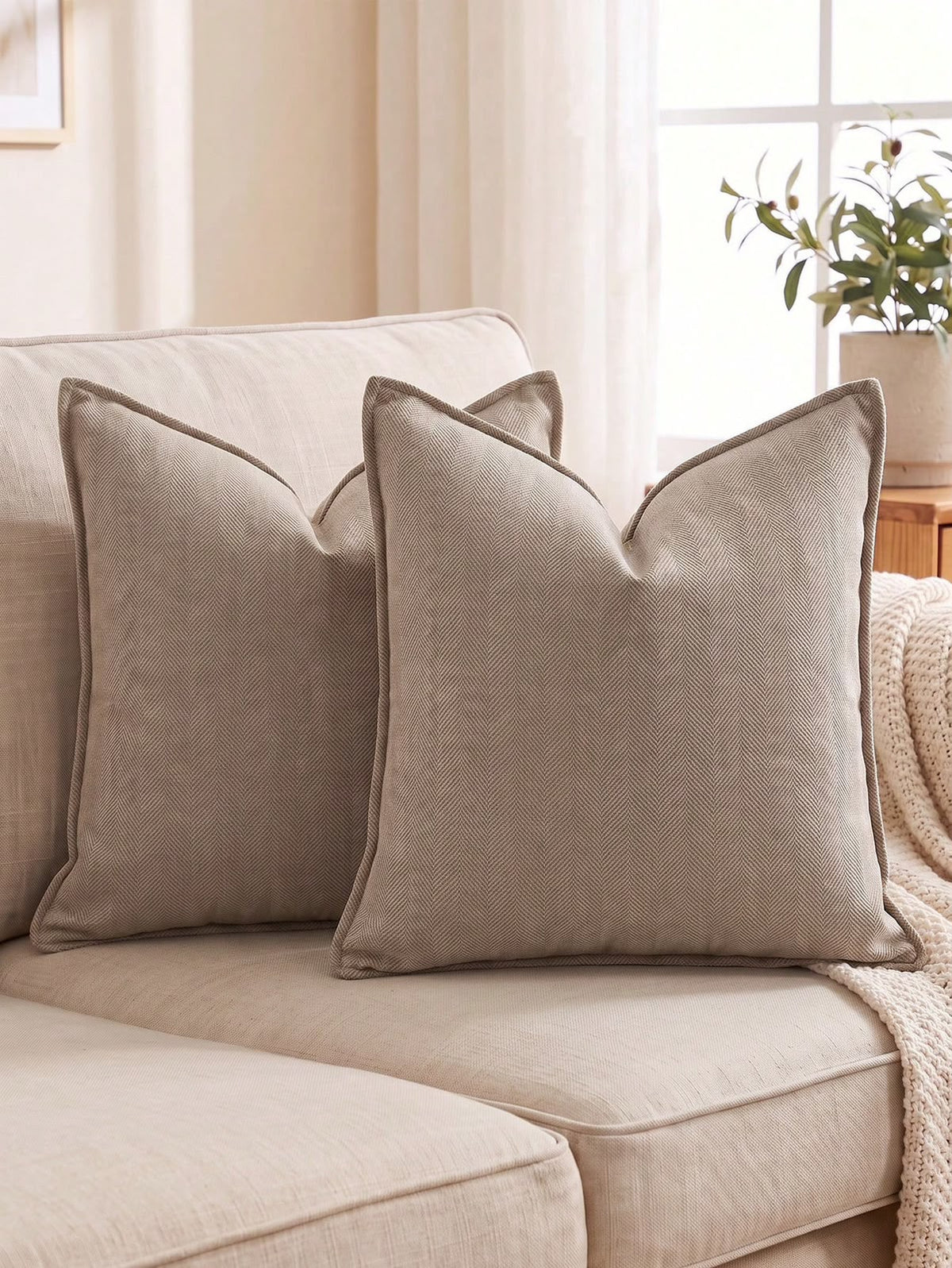 Taupe herringbone textured throw pillow covers styled on a neutral sofa